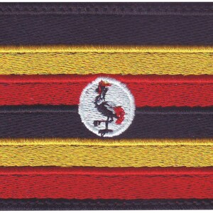 May include: A black, red, and yellow flag with a white circle in the center. The circle contains a black crowned crane with a red crest.