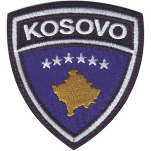 May include: A blue and gold embroidered patch with the word "KOSOVO" in white lettering and five white stars above a gold outline of the country's shape.