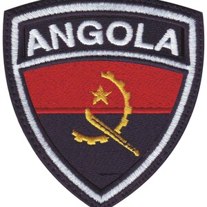 May include: An embroidered patch with a red, black, and yellow Angolan flag. The flag features a yellow star and a crossed machete and gear. The patch is surrounded by a white border and the word "ANGOLA" is embroidered in white on the top.