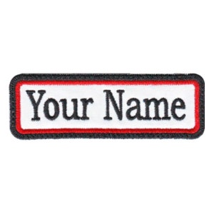 May include: White rectangular patch with a black border and red inner border. The text "Your Name" is embroidered in black.