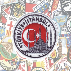 May include: Round embroidered patch featuring the Turkish flag and a mosque silhouette. The patch has the text "TÜRKIYE*ISTANBUL*" in a circular pattern. The background includes various travel-themed patches.