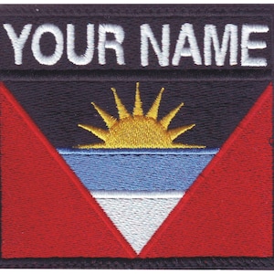 May include: Embroidered patch with the flag of Antigua and Barbuda. The flag features a red triangle with a white triangle inside, a blue stripe, and a yellow sun with rays. The text "YOUR NAME" is above the flag.
