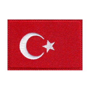 May include: A red embroidered patch with a white crescent moon and star, representing the flag of Turkey.