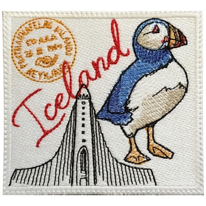 May include: Embroidered patch featuring a white background with a red "Iceland" text, a black and white illustration of a church, and a colorful illustration of a puffin. The patch also includes a yellow circular stamp with the text "Iceland" in black.