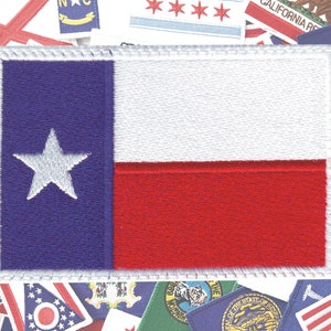 Peut inclure: Un patch blanc avec une étoile bleue dans le coin supérieur gauche, une bande blanche au milieu et une bande rouge en bas. Le patch est entouré d'une bordure blanche.