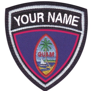 May include: A black and white embroidered patch with a red border. The patch features the flag of Guam with the words "YOUR NAME" above the flag.