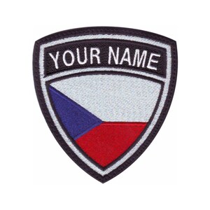 May include: A black and white embroidered patch with the Czech Republic flag in the center. The text "YOUR NAME" is embroidered in white on a black banner above the flag.