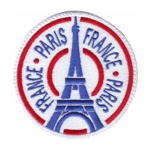 May include: A white, red and blue embroidered patch featuring an image of the Eiffel Tower with the text "France Paris" repeated around the edge.