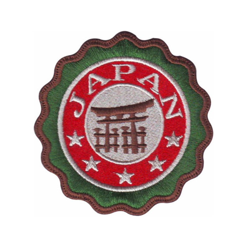 May include: A red, white, and green embroidered patch with the word "JAPAZ" in a circle around a brown silhouette of a Japanese torii gate. Five white stars are around the gate.