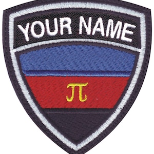 May include: Shield-shaped embroidered patch featuring the text "YOUR NAME" above a blue and red design. A yellow pi symbol is centered on the red section. The patch has a black border with white stitching.