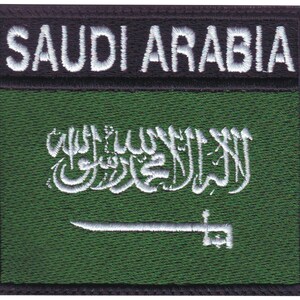 May include: Embroidered patch with the Saudi Arabian flag. The flag is green with a white inscription and a white sword. The patch has a black border with the words "SAUDI ARABIA" in white.