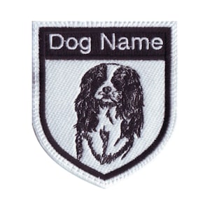 May include: White and black embroidered patch with a black and white Cavalier King Charles Spaniel dog breed silhouette. The patch has a black border and the text "Dog Name" at the top.