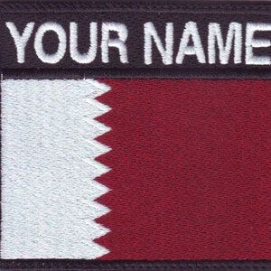 May include: A white and maroon embroidered patch with the text "YOUR NAME" in white on a black background. The patch features the flag of Qatar.