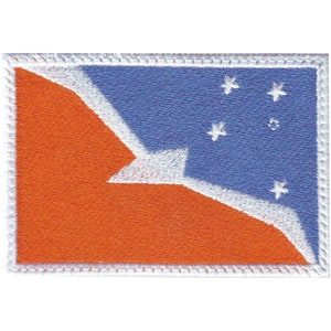 May include: An embroidered patch featuring the flag of American Samoa. The flag is a red triangle with a white border, set against a blue background with five white stars.