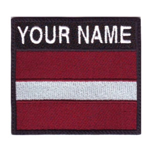 May include: An embroidered patch with the Latvian flag. The flag is red with a white stripe in the middle. The patch has a black border and the text "YOUR NAME" in white letters.