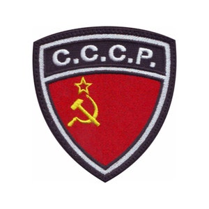 May include: A red, white, and black embroidered patch with a hammer and sickle and a star in the center. The text "C.C.C.P." is written in white on a black background.