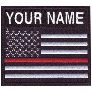 May include: Black embroidered patch with a red, white, and blue American flag and the text "YOUR NAME" above the flag.