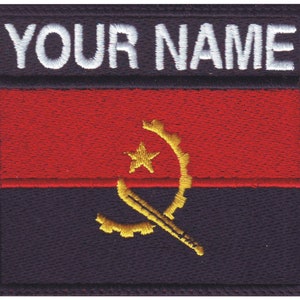 May include: Embroidered patch featuring the flag of Angola with the text "YOUR NAME" above it. The flag is red, black, and gold with a yellow star and a gear and machete symbol.