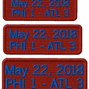 Peut inclure: Trois écussons rectangulaires brodés avec un fond rouge foncé et une bordure rouge assortie. Chaque écusson présente un texte bleu brodé indiquant May 22, 2018 sur la ligne supérieure et PHI 1 - ATL 3 sur la ligne inférieure en police sans-serif.