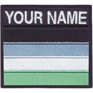May include: A black and white embroidered patch with the text "YOUR NAME" at the top. The patch features a horizontal stripe design in light blue, white, and green.