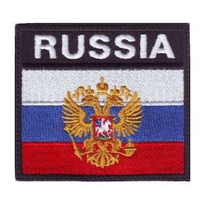 May include: Embroidered patch featuring the Russian flag with the coat of arms in the center. The flag is white, blue, and red with a gold double-headed eagle. The patch has a black border and the word "RUSSIA" in white letters.
