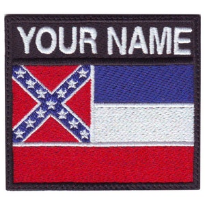 May include: A black patch with white text that says "YOUR NAME" and a Confederate flag with a blue, white, and red design.