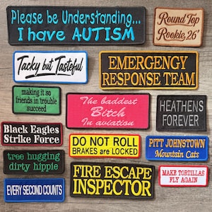 May include: A collection of rectangular embroidered patches featuring various text designs, including 'Please be Understanding... I have AUTISM', 'Tacky but Tasteful', 'EMERGENCY RESPONSE TEAM', 'The baddest Bitch In aviation', and 'FIRE ESCAPE INSPECTOR'.
