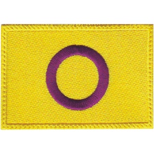 May include: A yellow embroidered patch with a purple circle in the centre.