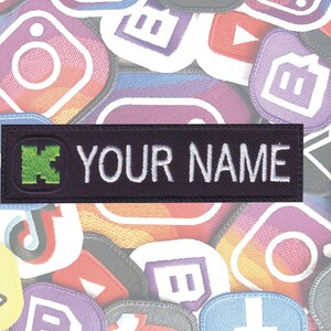May include: Black and green embroidered patch with a letter "K" and the text "YOUR NAME" in white.