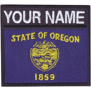 May include: A black and white embroidered patch with the text "YOUR NAME" at the top and "STATE OF OREGON" with the state seal and the year "1859" below.