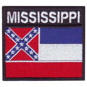 May include: An embroidered patch featuring the Mississippi state flag. The flag is red, white, and blue with a Confederate battle flag in the top left corner. The words "MISSISSIPPI" are embroidered in white on a black background above the flag.