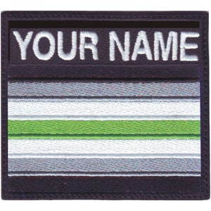 May include: A black and white embroidered patch with a green stripe in the center. The patch has the text "YOUR NAME" at the top.