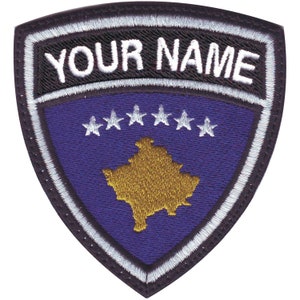 May include: A shield-shaped patch with a white border and the text "YOUR NAME" at the top. The patch features a blue background with five white stars and a gold-colored outline of a country.