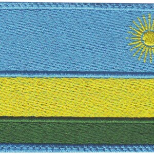 May include: Embroidered patch featuring the flag of Rwanda. The flag design includes a light blue upper section, a yellow middle section, and a green lower section. A yellow sun with rays is in the upper right corner. The patch has a blue border.