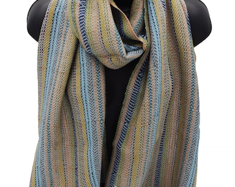 May include: A striped scarf with a blue, green, yellow, and pink color scheme. The scarf has a fringe on the ends and is made of a soft, woven fabric. The scarf is displayed on a black mannequin.