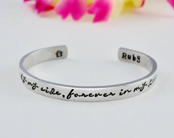 May include: Silver bracelet with the inscription "By my side, forever in my heart" and the name "Ruby" engraved on the side.