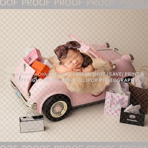 May include: A pink toy car with a baby doll inside. The car is filled with shopping bags and boxes. The bags have the words "CHANEL" and "GUCCI" printed on them.