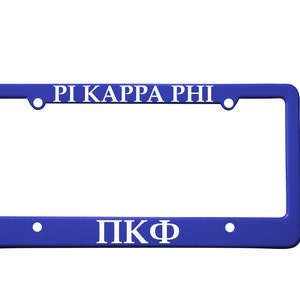 May include: Blue plastic license plate frame with white lettering that reads "Pi Kappa Phi" and "ΠΚΦ".