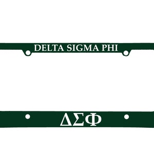 May include: Green license plate frame with white lettering that reads "DELTA SIGMA PHI" and "ΔΣΦ".