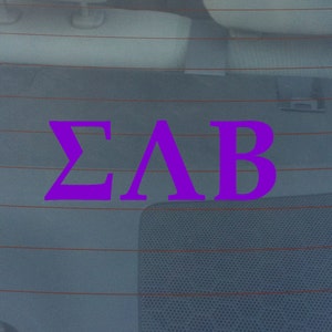 May include: A purple vinyl decal with the Greek letters "ΣΛΒ" on a car window.