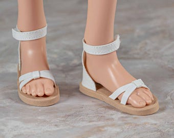 Sandalias para muñeca inteligente en piel sintética blanca con tiras cruzadas, tacón liso y correa en el tobillo para muñeca inteligente.