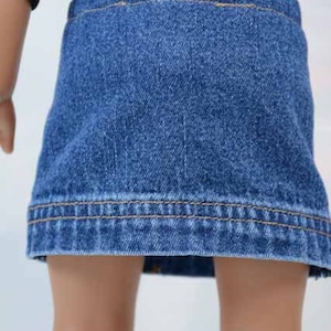Puede incluir: Una falda vaquera para una mu&ntilde;eca, de color azul oscuro y con un dobladillo marr&oacute;n claro.