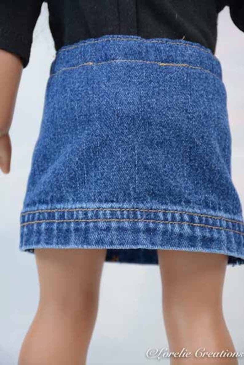 Puede incluir: Una falda vaquera para una mu&ntilde;eca, de color azul oscuro y con un dobladillo marr&oacute;n claro.