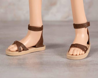 Sandalias para muñeca inteligente en piel sintética color marrón chocolate con tiras cruzadas, tacón liso y correa en el tobillo para muñeca inteligente.