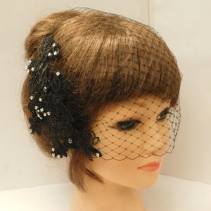 May include: Black bridal veil with a black lace applique adorned with rhinestones and black beads.