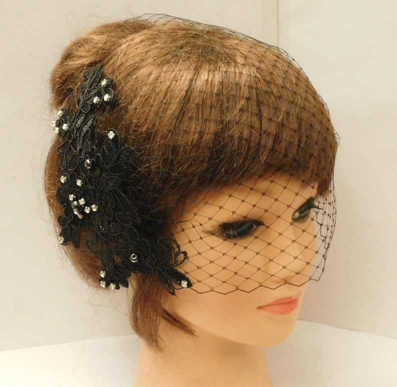 May include: Black bridal veil with a black lace applique adorned with rhinestones and black beads.