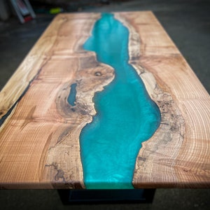 May include: A wooden table top with a turquoise blue epoxy resin river running through the center.