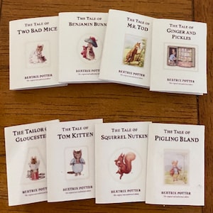 Może przedstawiać: Kolekcja ośmiu miniaturowych książek z ilustracjami z klasycznych opowieści dla dzieci Beatrix Potter. Książki zawierają "The Tale of Two Bad Mice", "The Tale of Benjamin Bunn", "The Tale of Mr. Tod", "The Tale of Ginger and Pickles", "The Tailor of Gloucester", "The Tale of Tom Kitten", "The Tale of Squirrel Nutkin" i "The Tale of Pigling Bland".