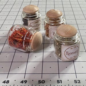 Juego de 4 frascos para almacenar hierbas con tapas de madera, con hierbas reales en el interior, que parecen tan reales en tamaño 1:12 para casas de muñecas o miniproyectos.
