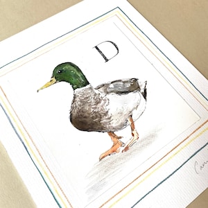 D es para pato, ilustración original firmada con letras A-Z de Camilla Seddon montada en una tabla de montaje adornada a mano